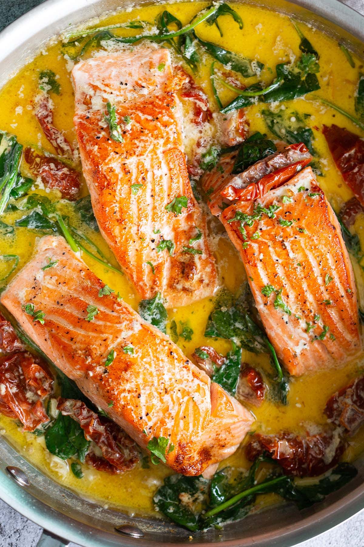 Tuscan salmon in a skillet.