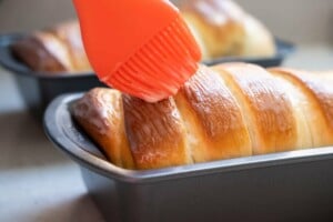 Coating the condensed milk bread with condensed milk glaze