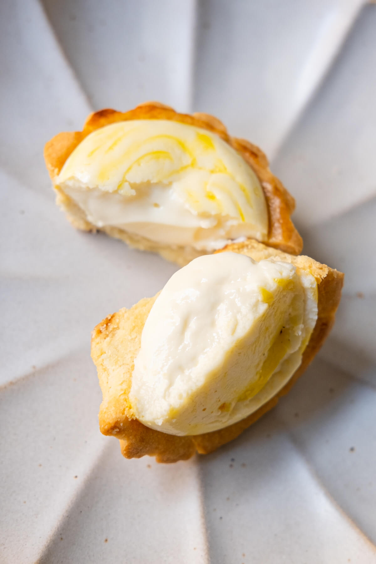 A top down shot of a half opened tart with luscious cream cheese filling encased in a perfectly baked golden crust.