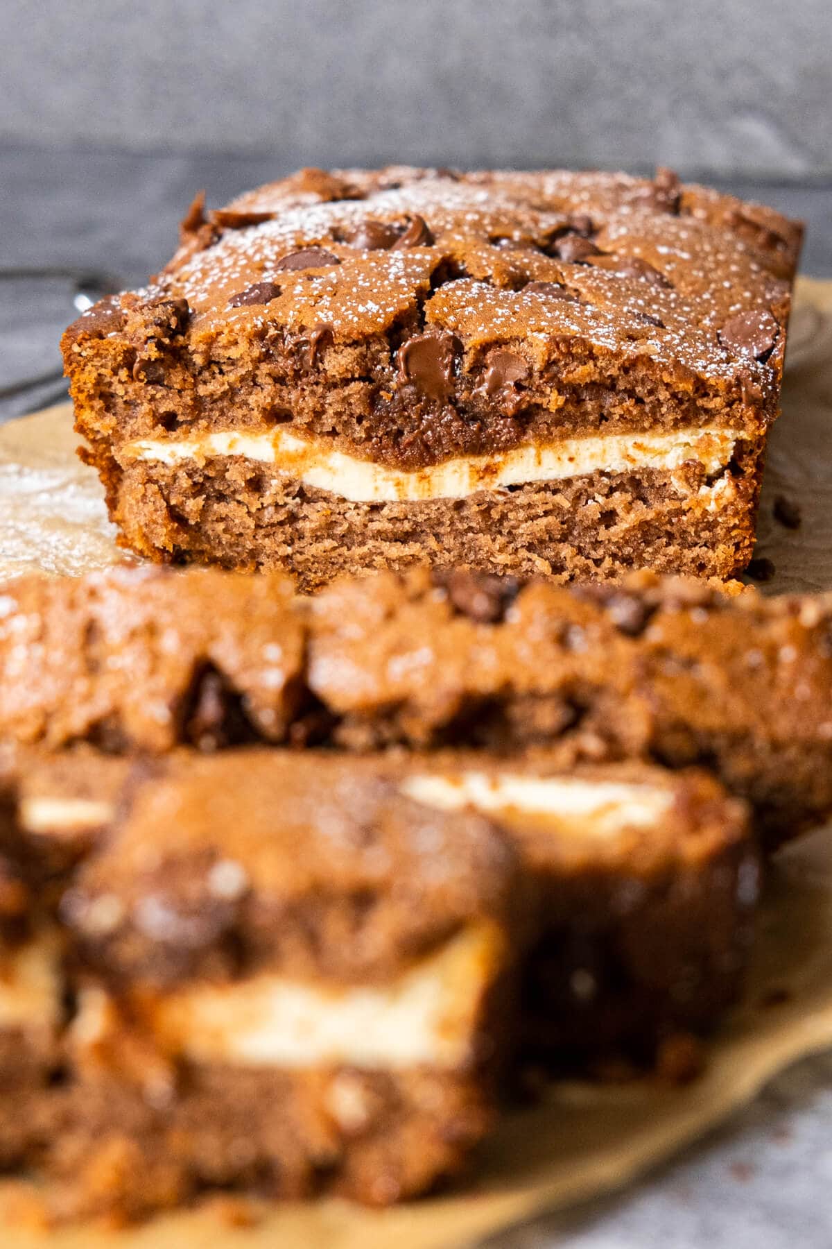 A close-up view of a moist and indulgent chocolate cake topped with a smooth layer of cream cheese frosting. 