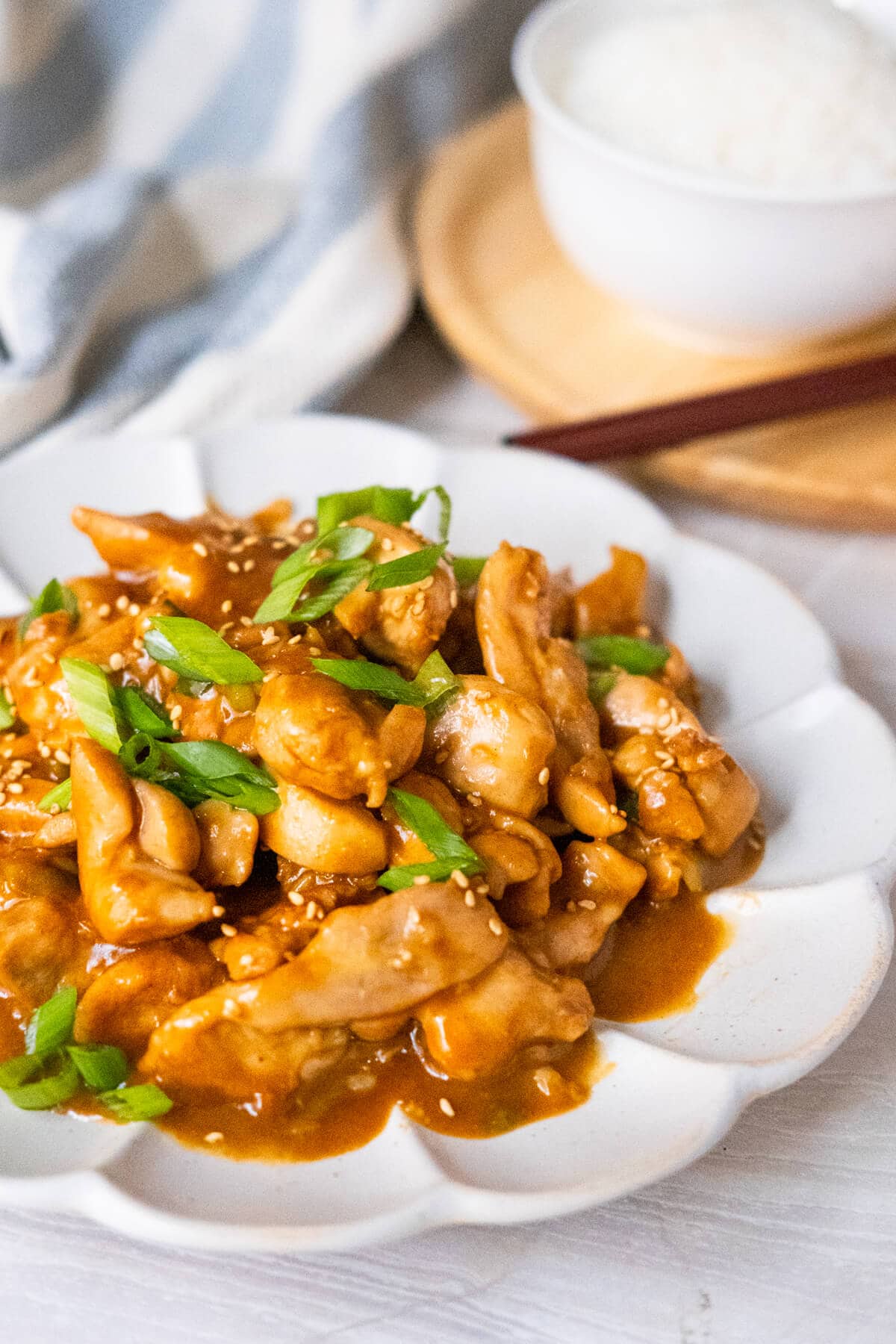 A plate of tender chicken thigh strips coated with sweet and savory bourbon sauce served in a white plate. 