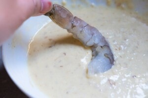 Coating the shrimp with batter.