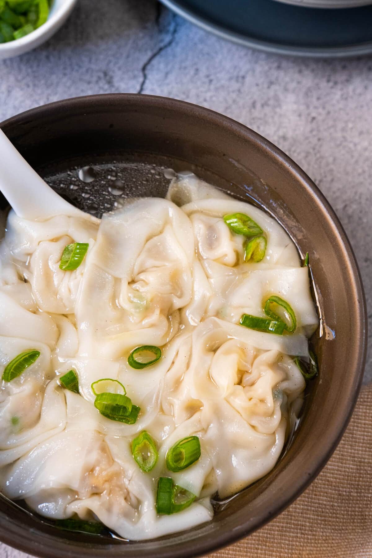 Chicken wonton soup served in a Chinese bowl.