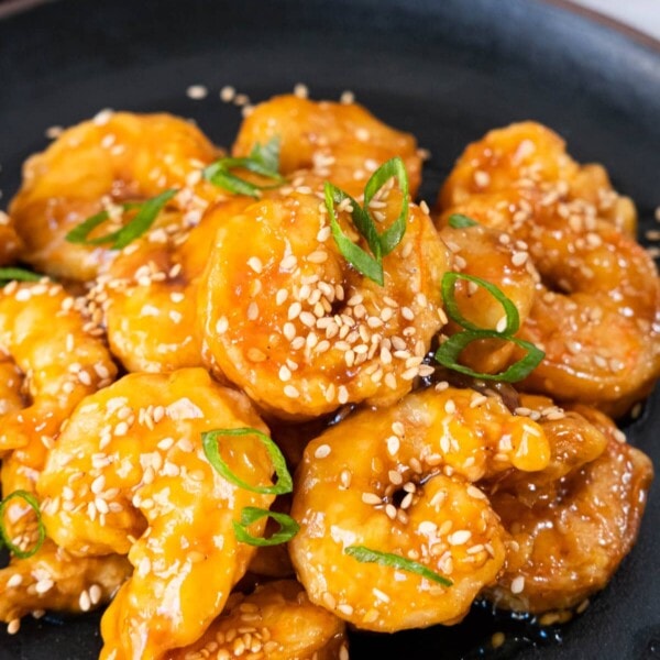 Sesame Shrimp on the plate with a black saucer and the napkin in modena on the side.