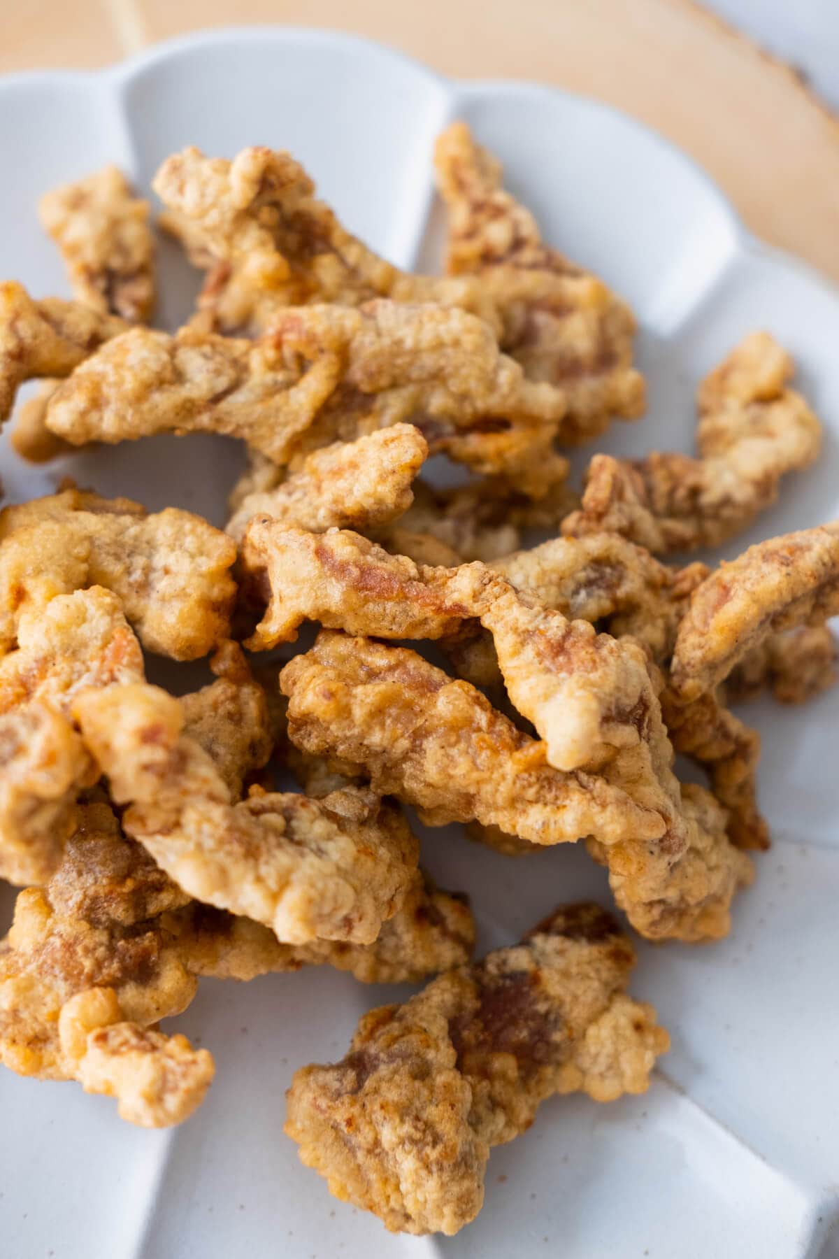 Crispy golden brown fried pork shoulder strips served on a white plate. 