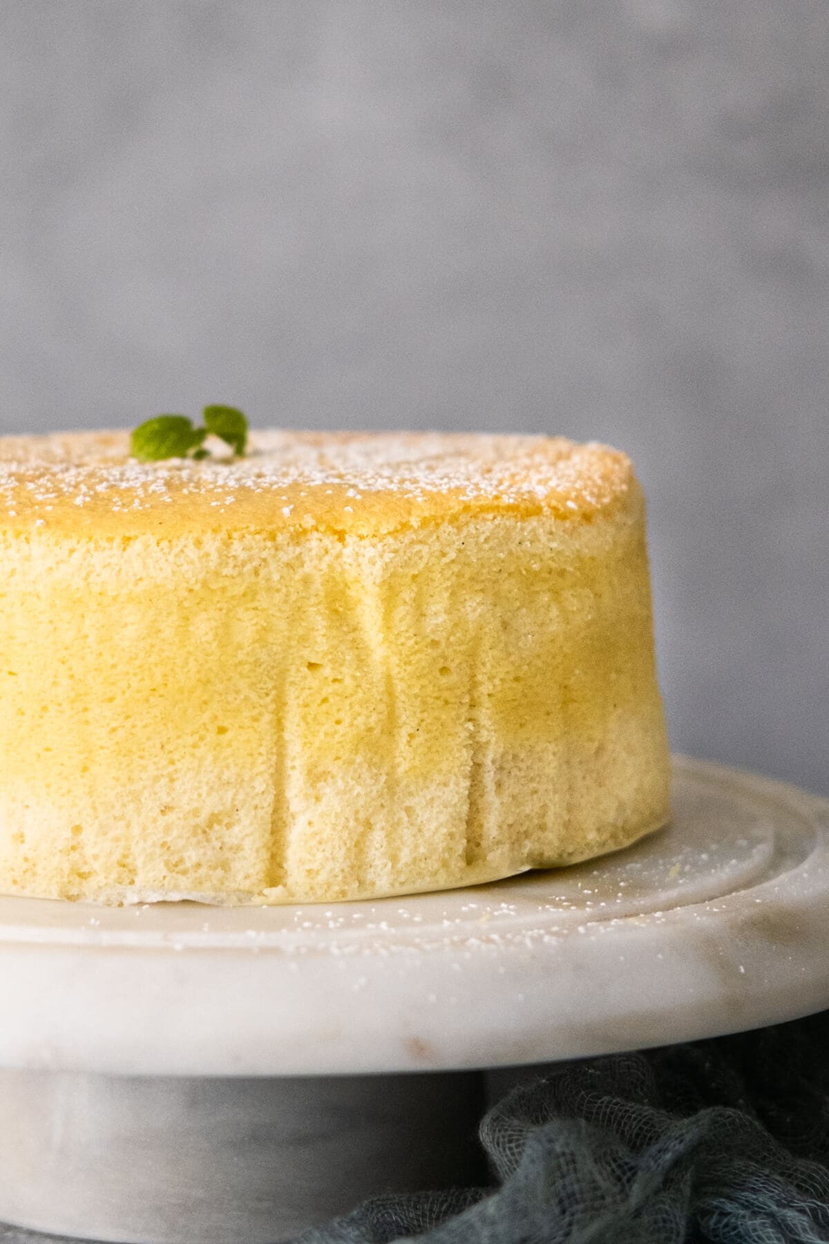 A side view of cake on the white marble stand.