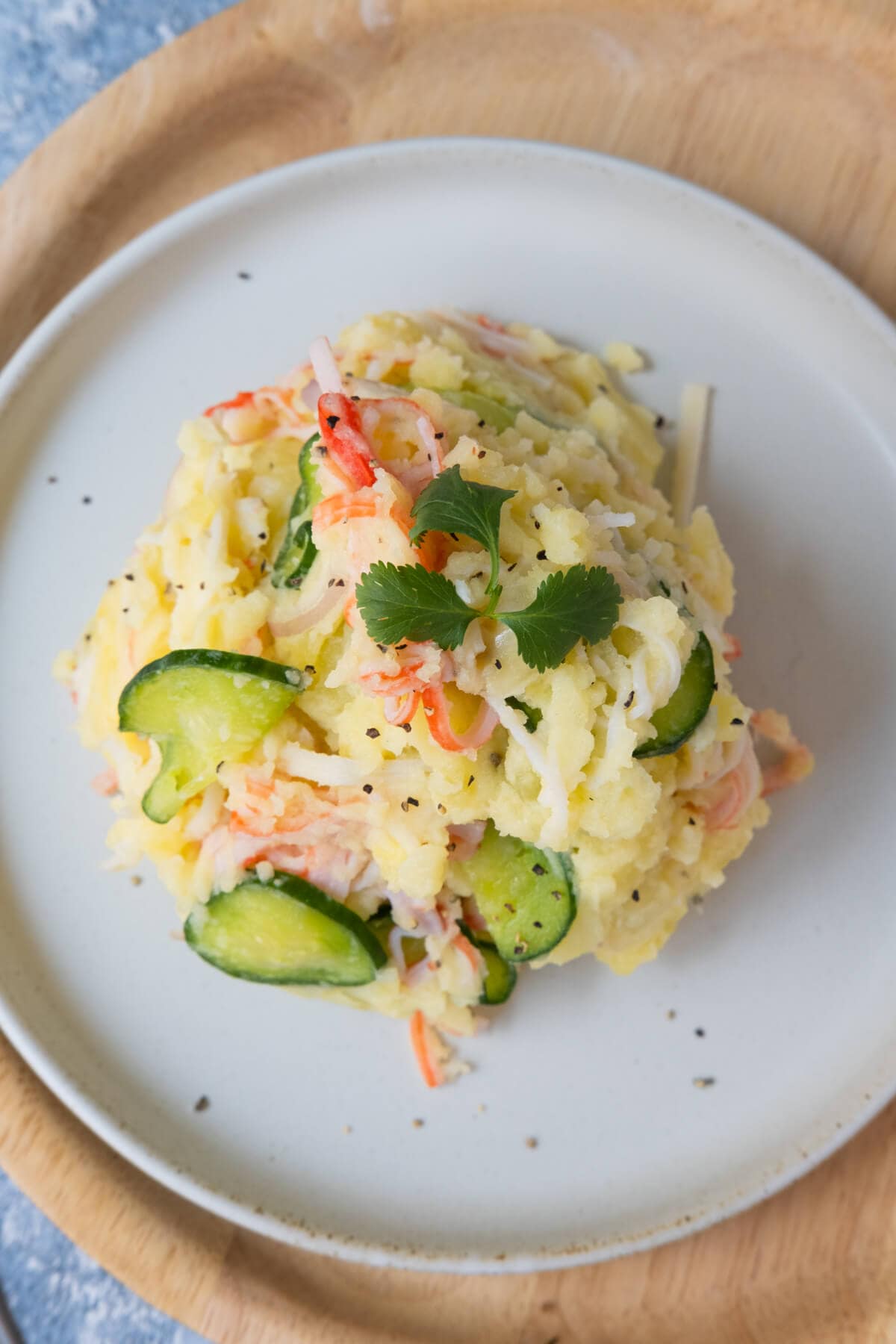 Japanese potato salad with fresh parsley on top and sprinkled with ground black pepper. 