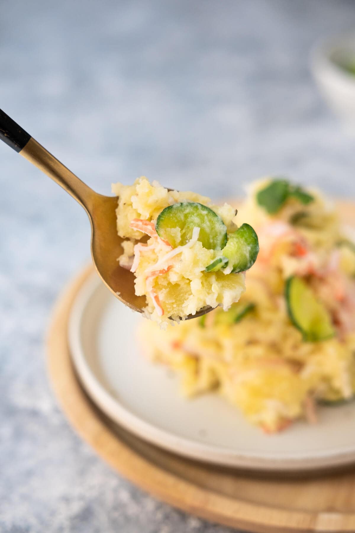 A spoonful of Japanese potato salad scooped with spoon. 