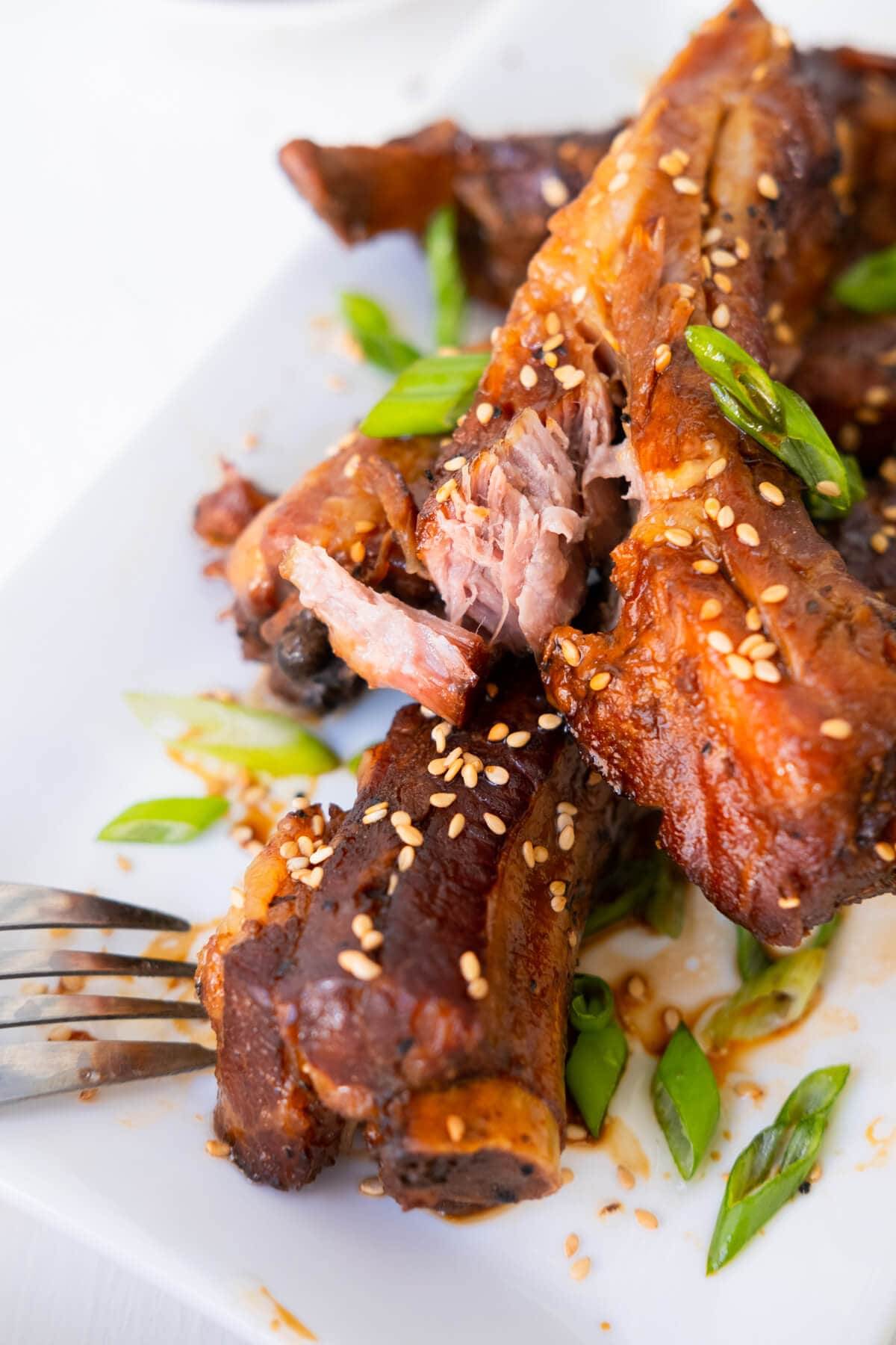 Bone ribs coated with teriyaki sauce with slaw served on a plate. 