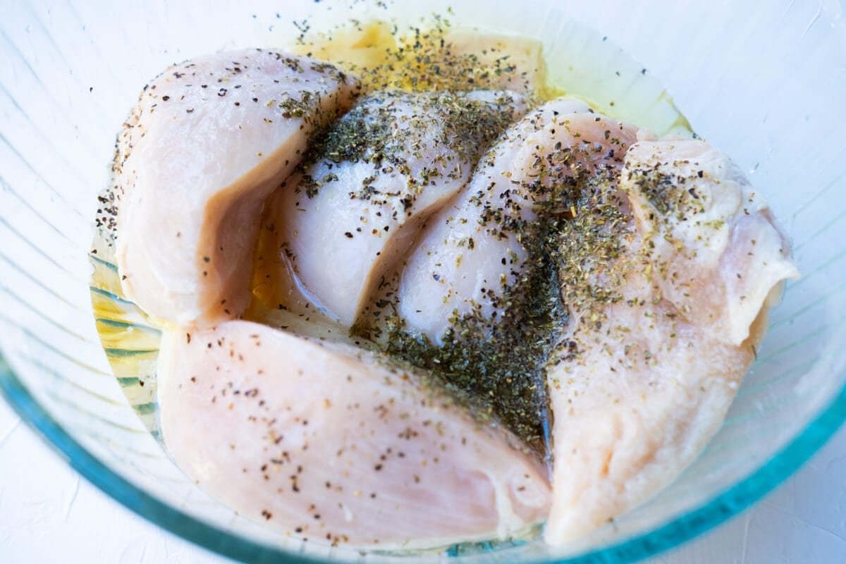 Chicken breast marinated with the marinade in a bowl.