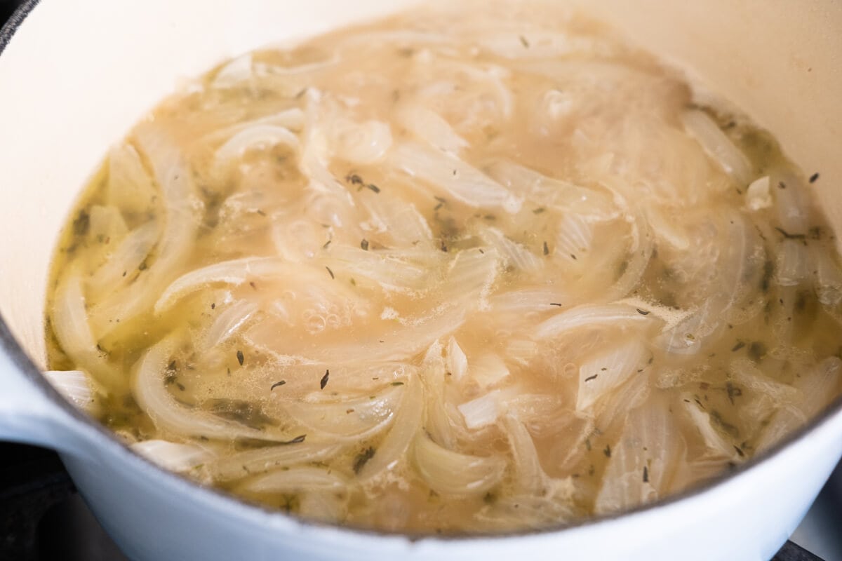 Onion slices that are cooked into soft and translucent in a pot. 