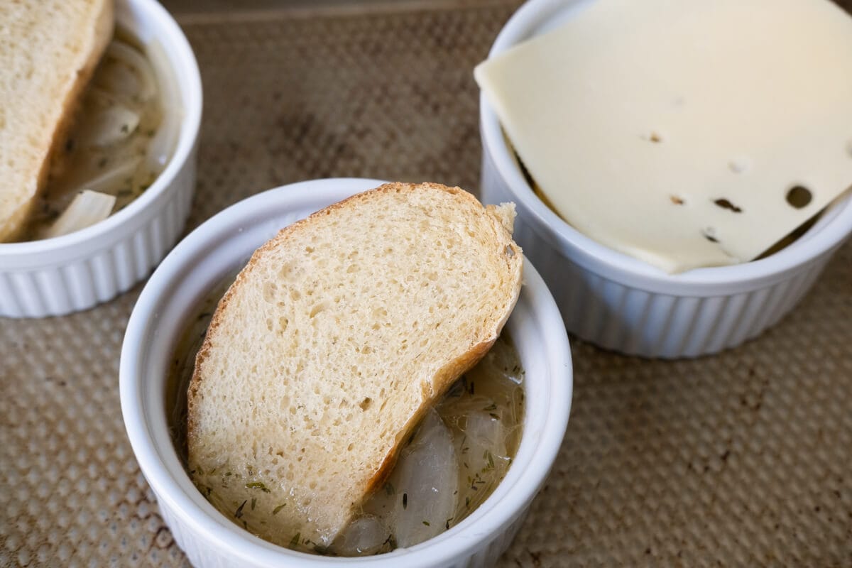 Cooked soup ladled into oven-safe ramekins and topped with bread, three kinds of cheese and broil. 