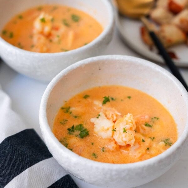 Shrimp bisque soup with bite size shrimp and freshly chopped parsley on top, and served with crouton on the side.