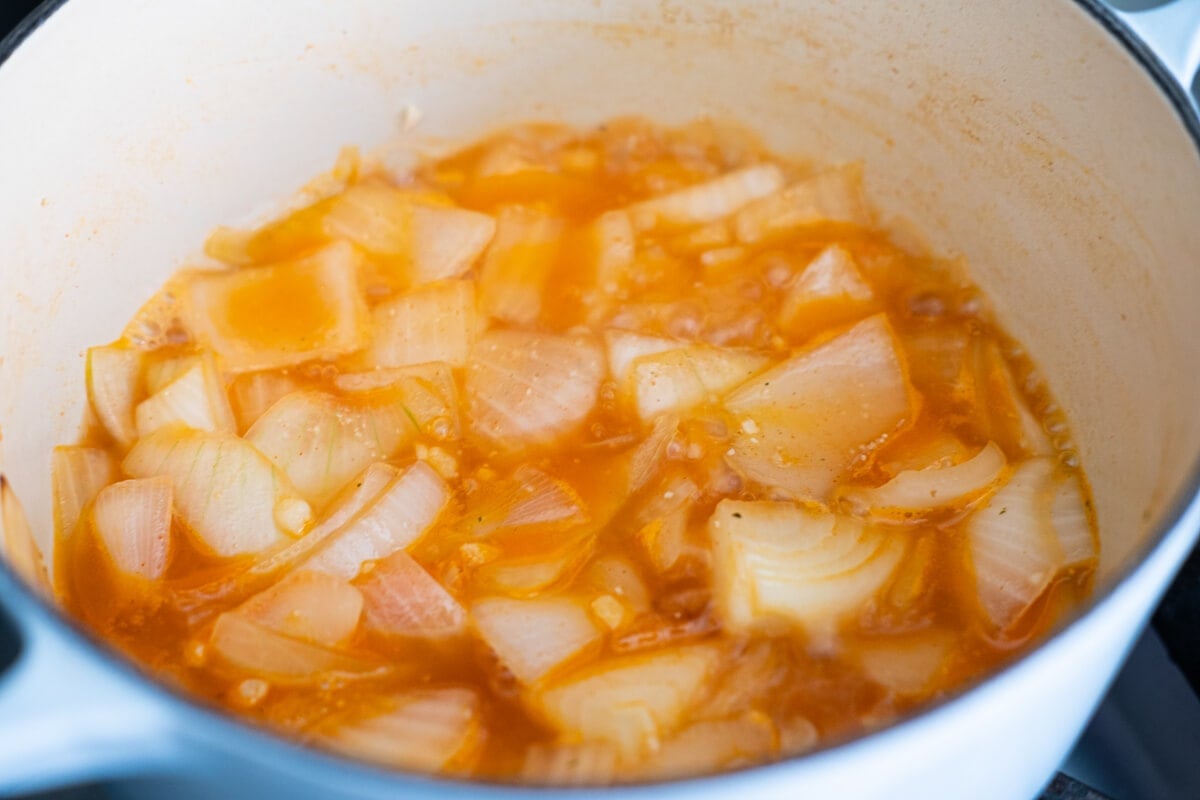 Onion and garlic simmered in tomato paste and clam juice in a pot. 