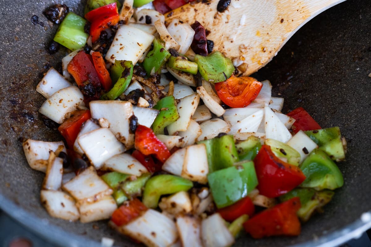 Green, red bell peppers, onion and fermented black bean stir fried in the wok. 