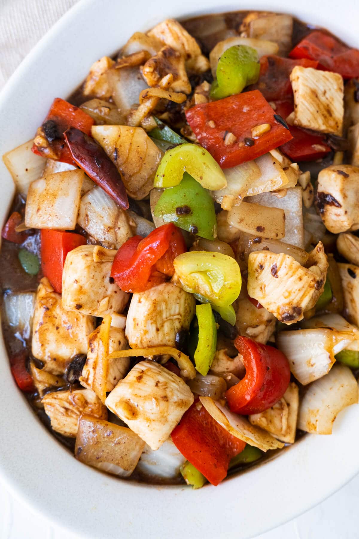 Easy and quick black bean sauce chicken in a white shallow plate. 