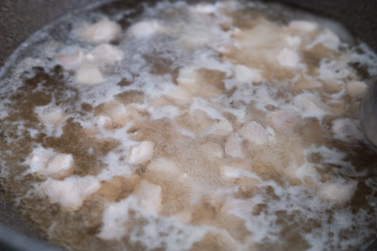 Chicken breast boiled with chicken stock and water in the pot. 