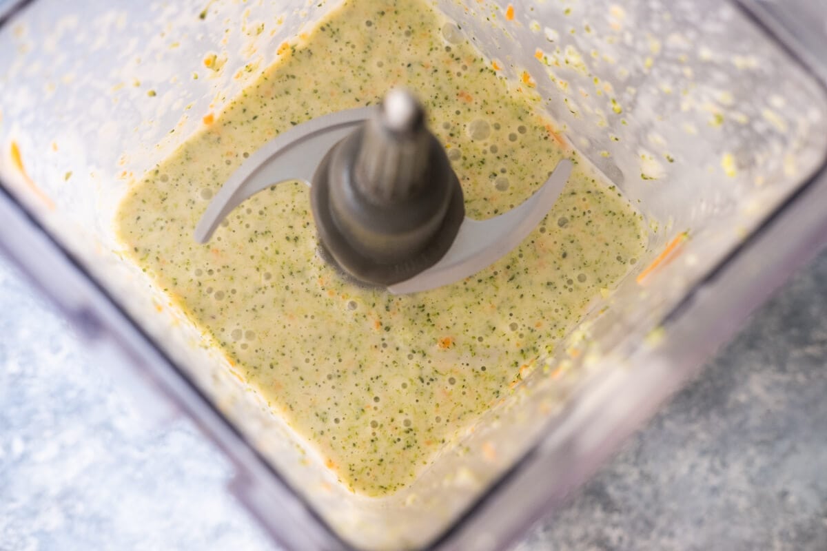 Half of the soup blending in a blender.