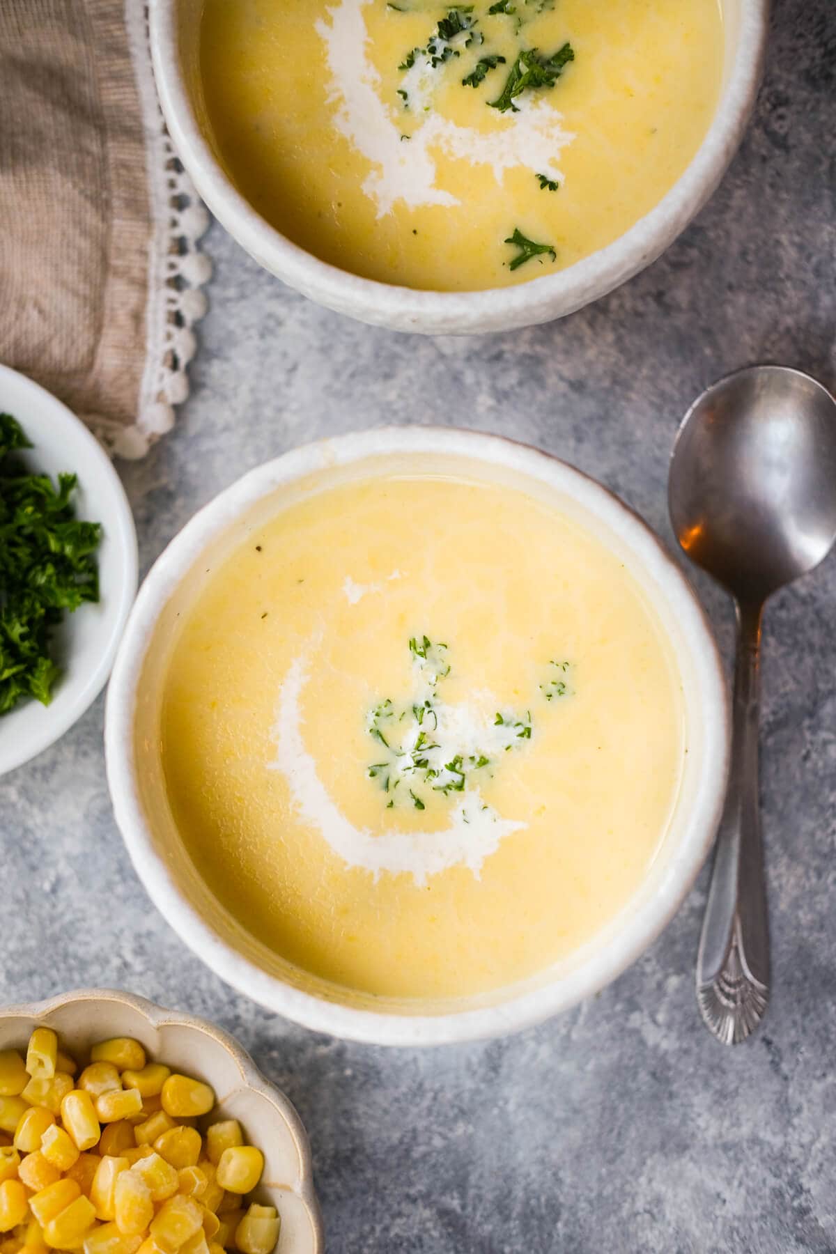 Two bowl of creamy Japanese corn soup and a cup of corn on the side. 