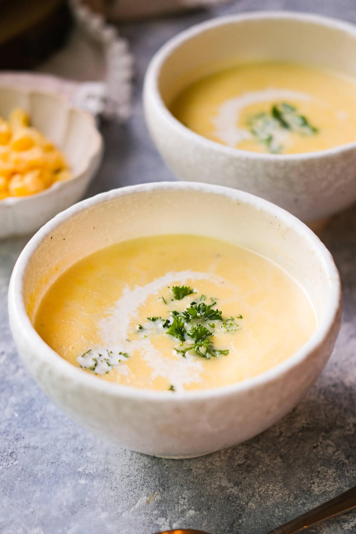 Yellow soup served in bowls of roasted corn on aside. 