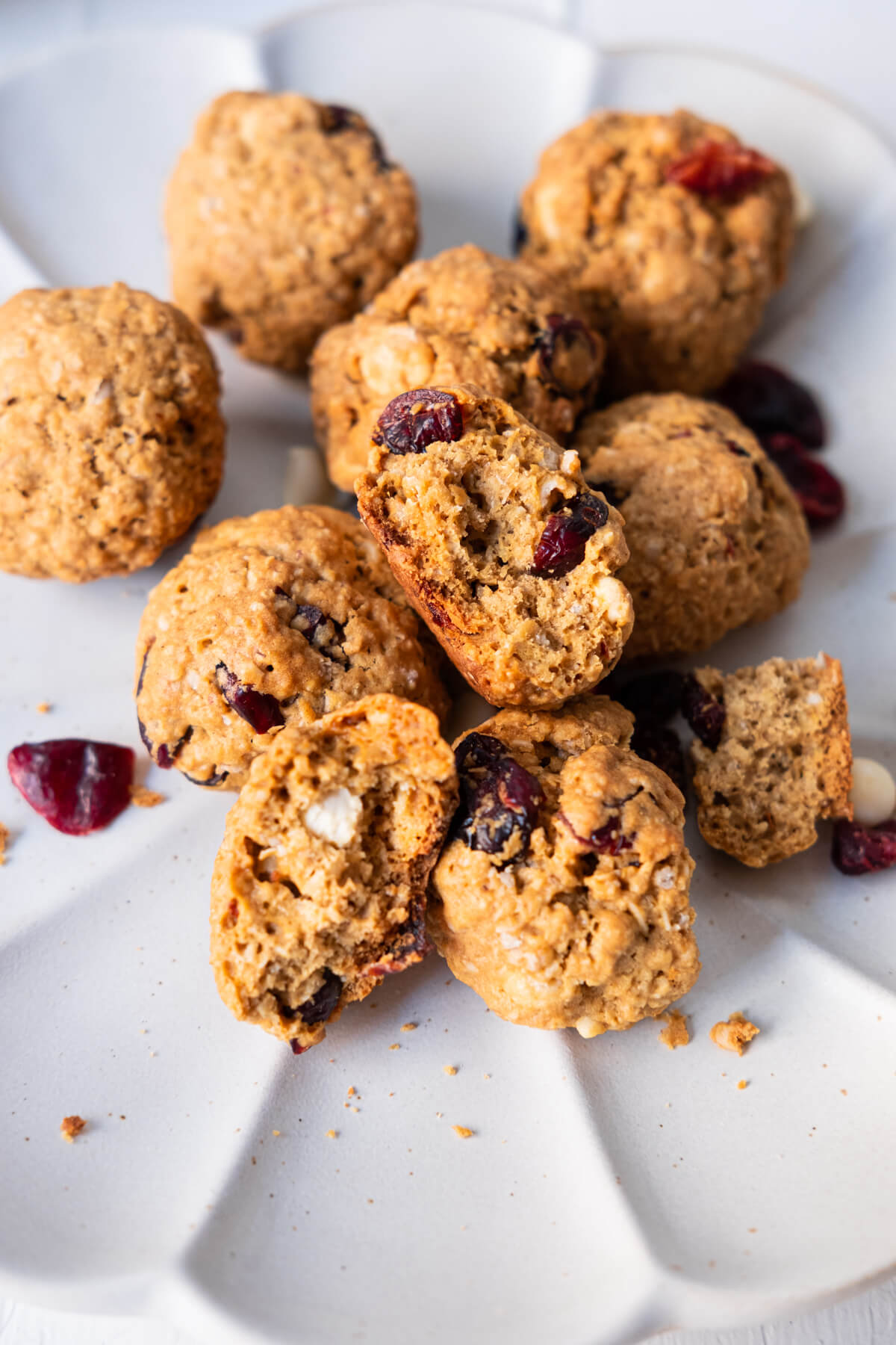 Cookies broken up into half revealing  chocolate chips and dried cranberries in the center. 