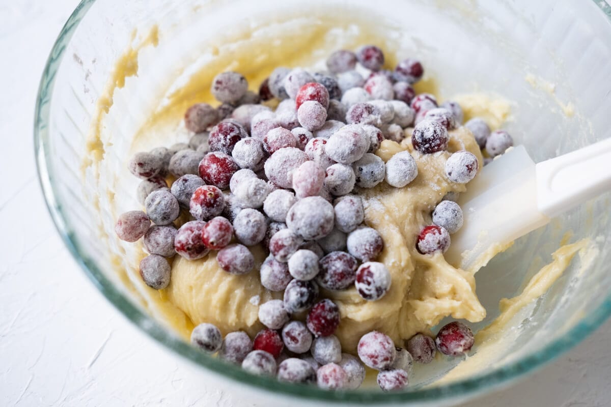 Frozen cranberry mixed with dough in a bowl. 