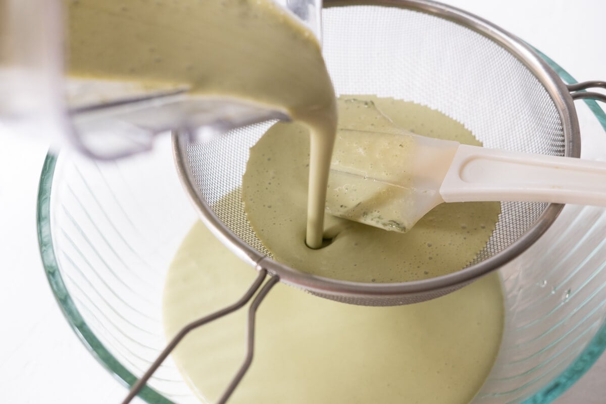 Batter being strained into a bowl. 