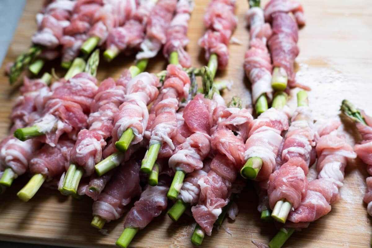 Asparaguses wrapped with raw thinly sliced pork. 