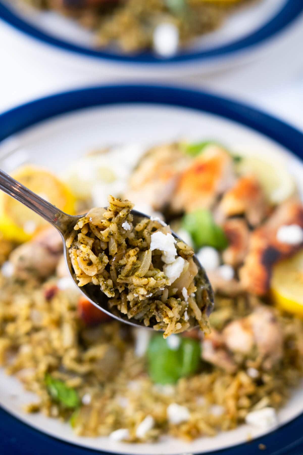 A spoonful of rice coated with spinach Greek yogurt sauce. 