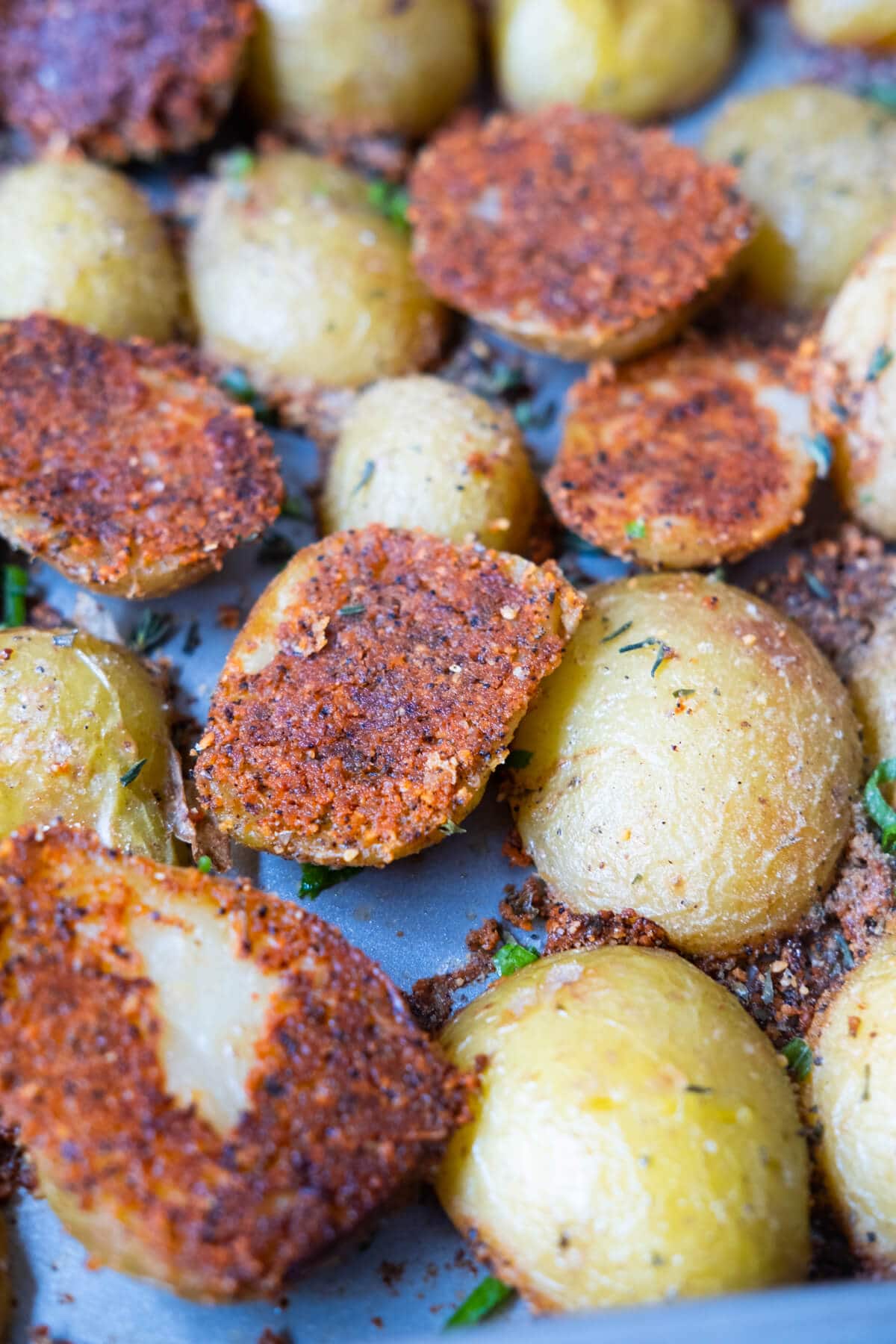 Baked potatoes with cheese, Italian seasoning, and paprika on top baked crispy on the outside and tender from the inside. 