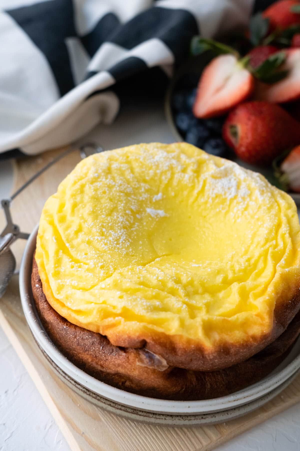 Golden brown greek yogurt cake with sugar powder dusting on top served in a plate. 