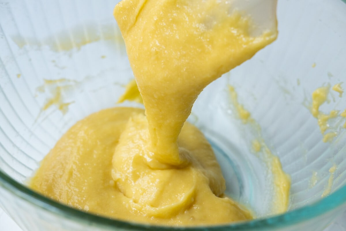 Choux pastry dough being mixed in a bowl. 