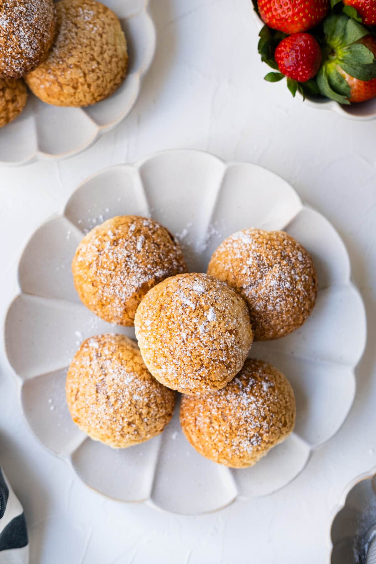 Golden brown cream filled choux pastry with fresh strawberries served aside. 