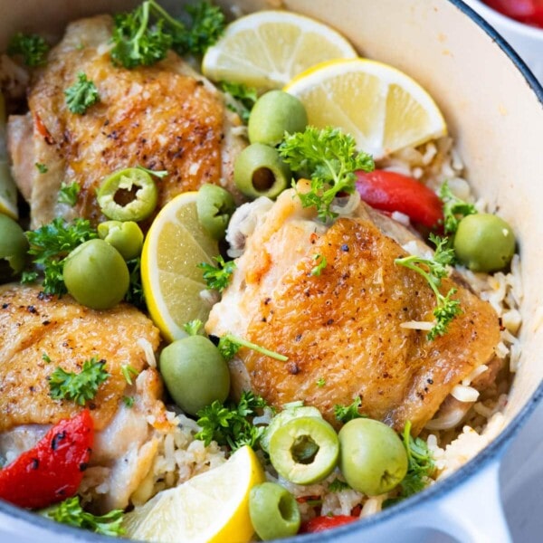 One-pot cajun chicken and rice topped with olives, lemon wedges and parsley.