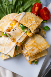 Chicken and bacon quesadilla served on lettuce and tomatoes aside.