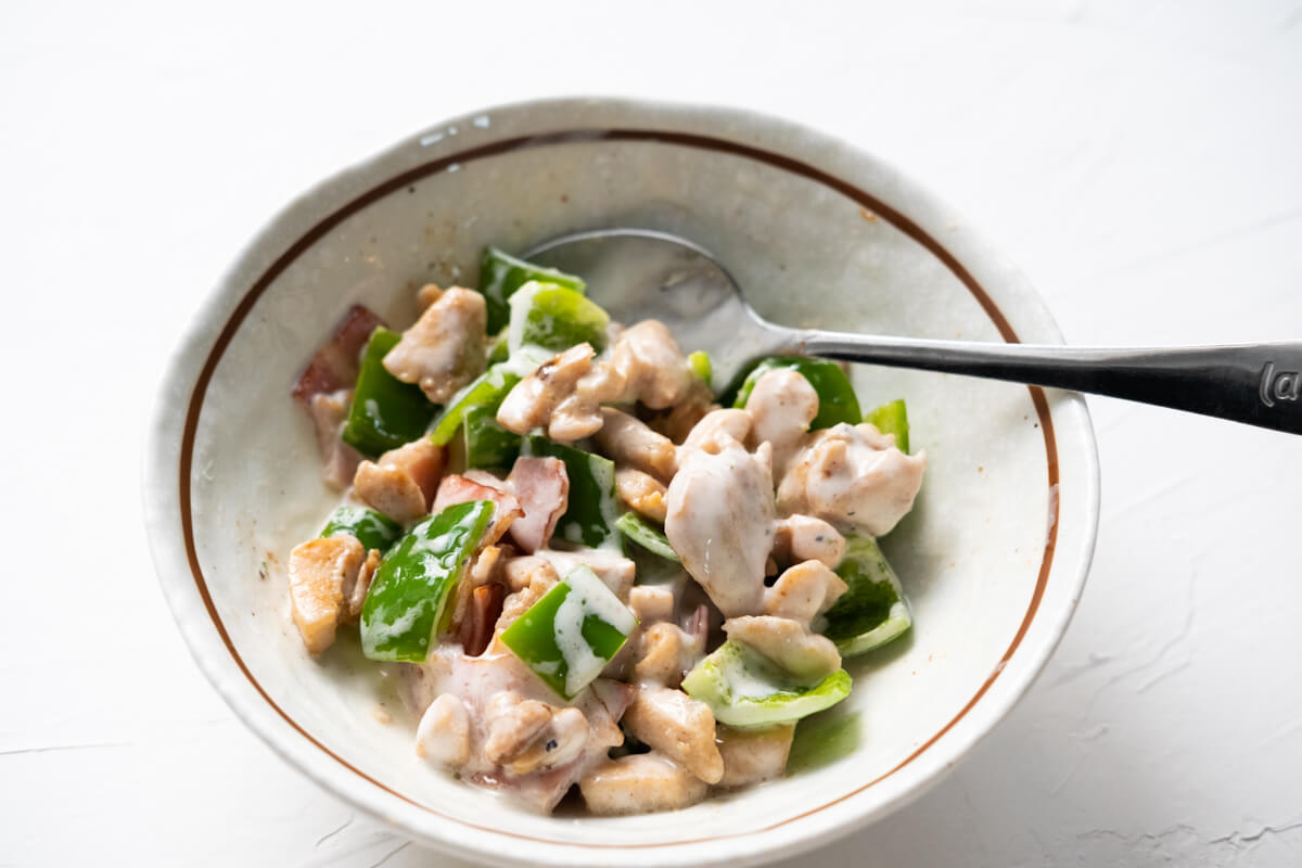 Cooked chicken, bacon, green pepper, and ranch mixed in a small bowl. 