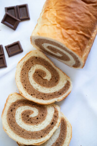 Chocolate cake bread with a few chocolate bar on the side.