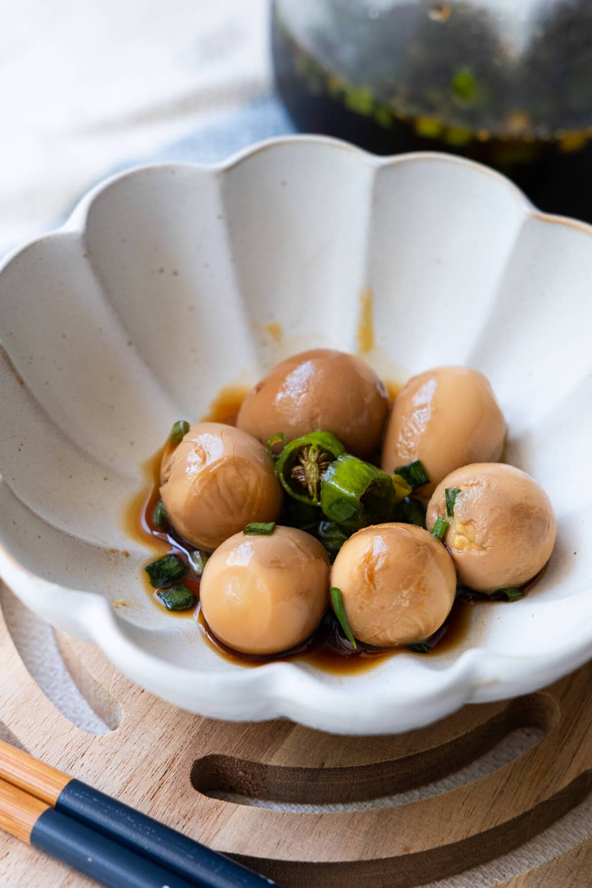 Flavorful soy sauce eggs in a small plate with chili pepper. 