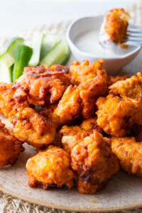 Buffalo chicken bites are served with ranch dressing and fresh cucumber.