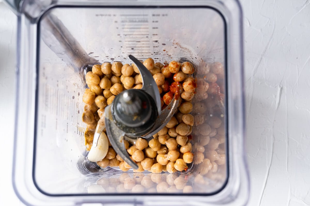 Chickpeas, garlic, tahini, salt, ground cumin, half of paprika, and lemon juice in a blender. 