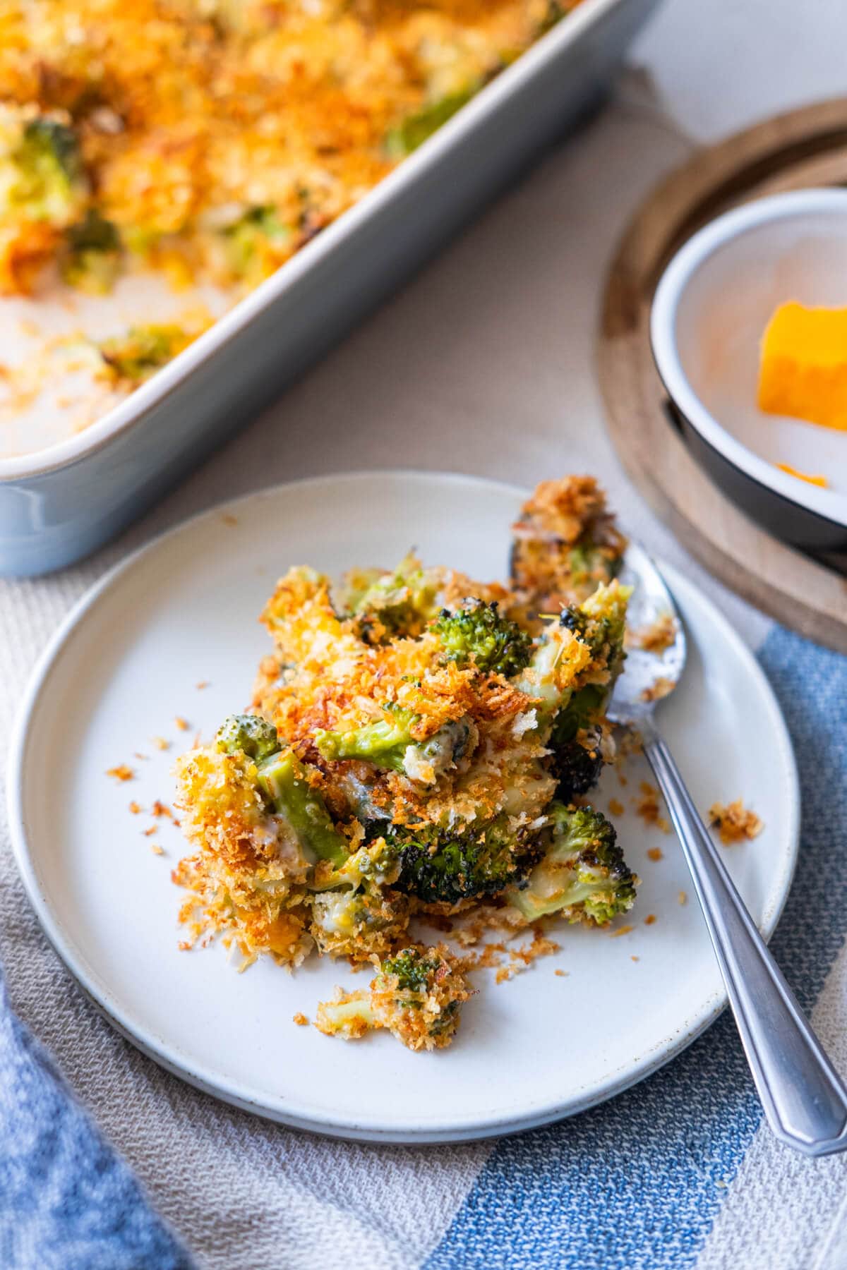 A serving portion of broccoli gratin served in a flat white plate. 