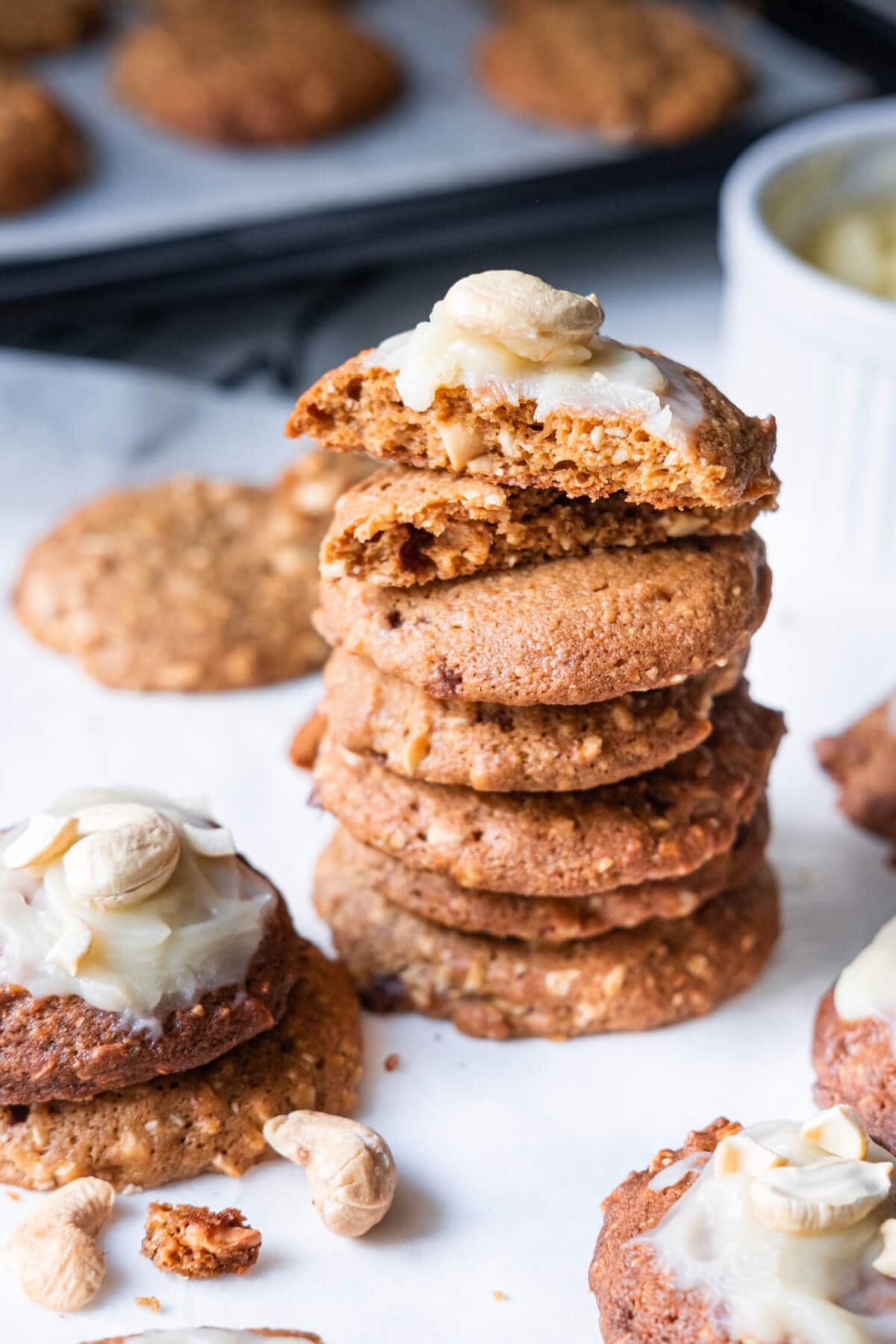 Stacked crumbly cookies with cashews in between topped with white frosting.  