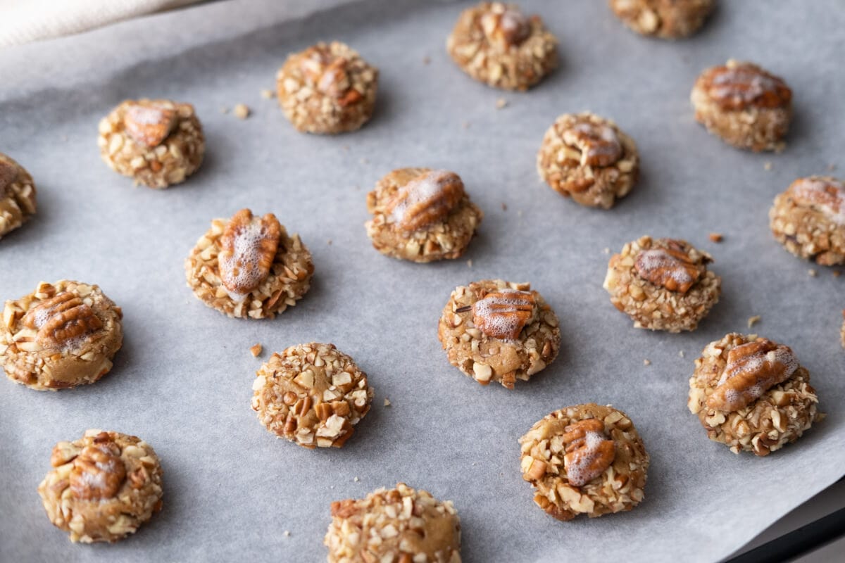 Cookie dough in round placed on a baking sheet lined with parchment paper. 