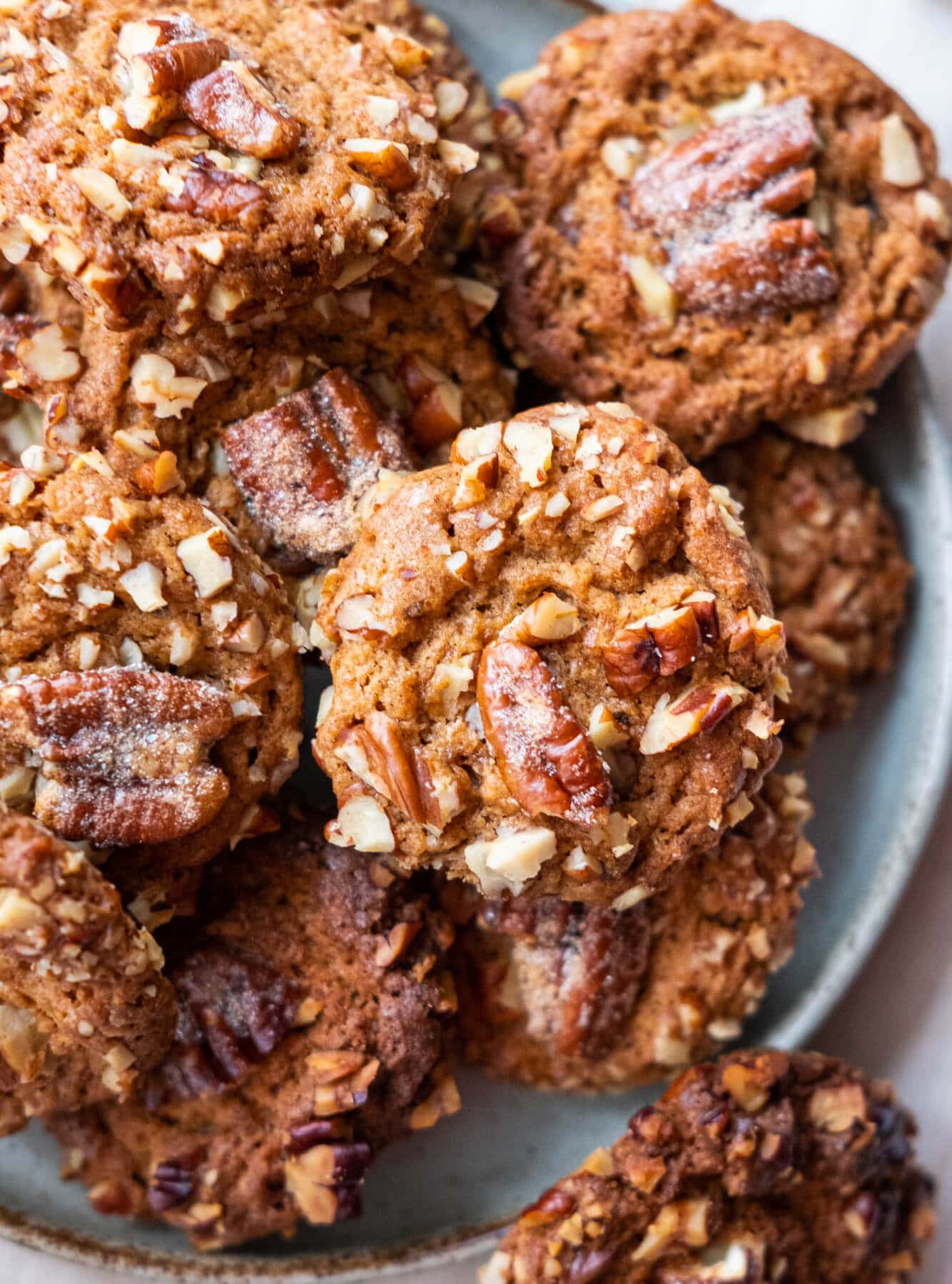 Close up shot of crunchy buttery cookies topped with pecans. 