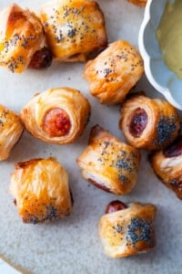 Pig in blankets with poppy seeds on top.