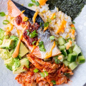 Baked salmon, diced avocado, cucumber, and kimchi over rice bowl and drizzled with spicy mayo.