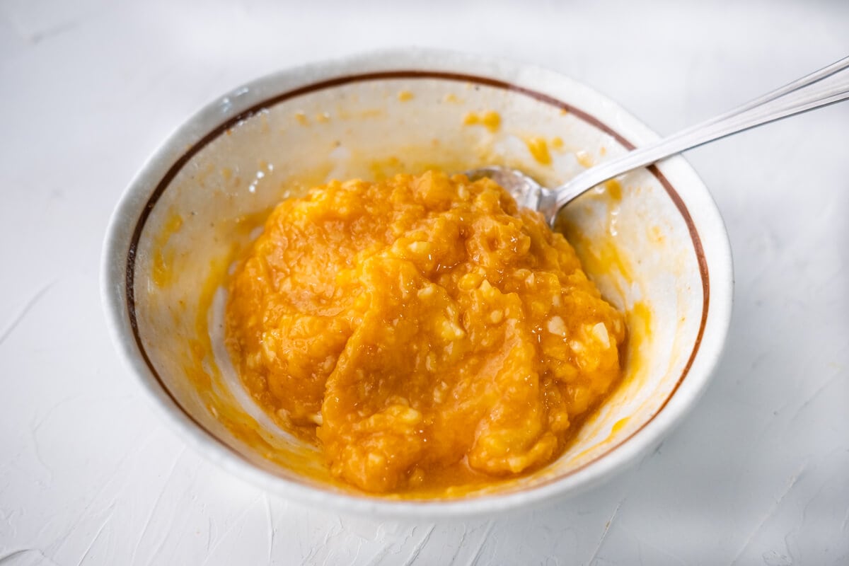 A bowl of miso mixture combined with melted butter, white miso, sriracha, sugar, garlic, and ginger. 