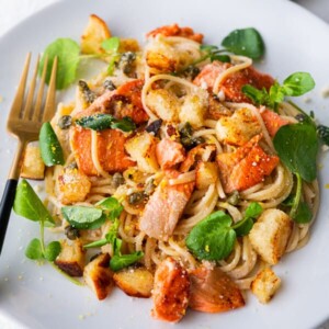 Salmon spaghetti cooked with lemon and garlic sauce, and topped with watercress leaves and baby capers.