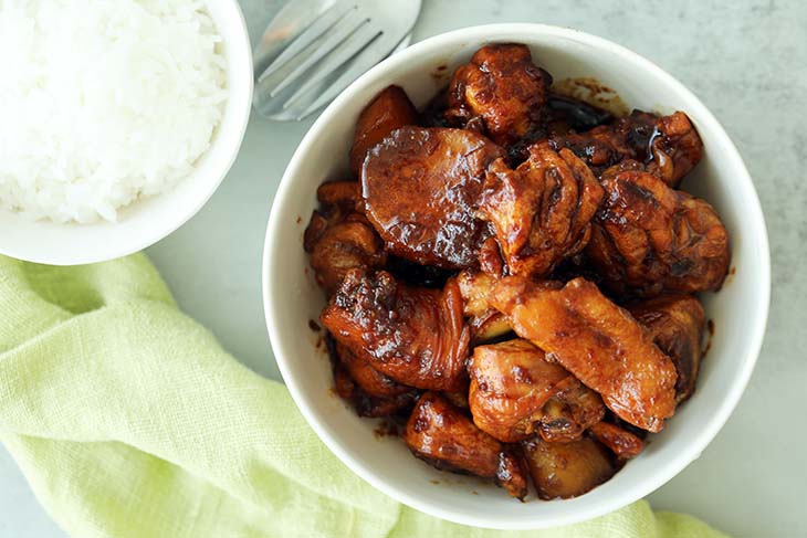 Ayam Pongteh served in a bowl with rice. 