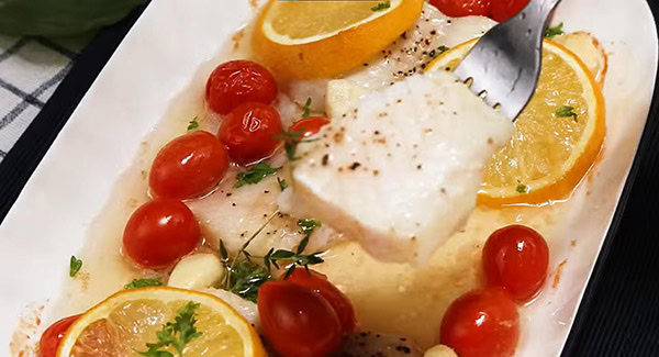 A piece of baked catfish on a fork.